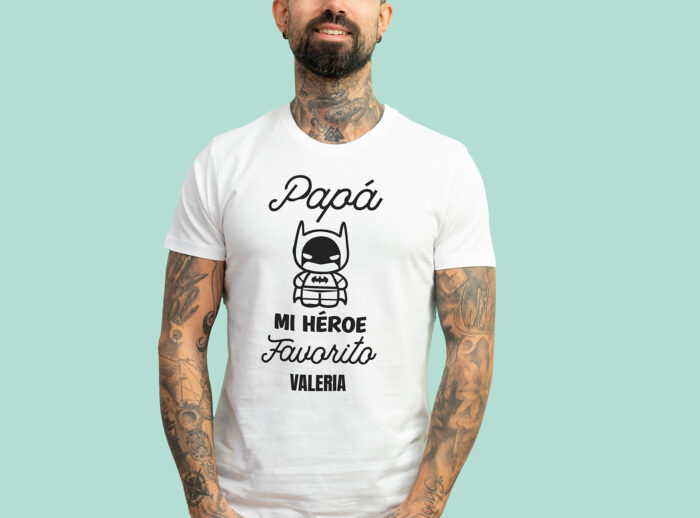 Camiseta blanca Papá mi héroe favorito Camiseta blanca con la frase 'Papá, mi héroe favorito', adornada con un dibujo de un superhéroe y personalizada con el nombre que elijas.