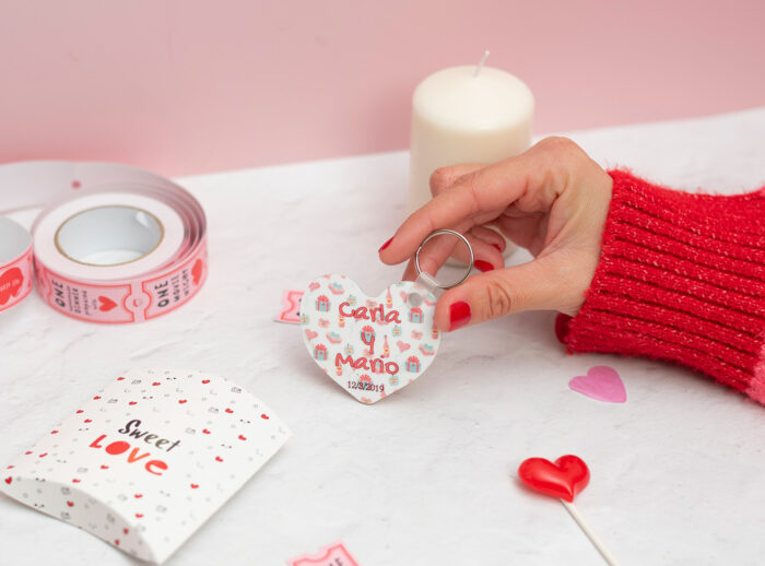 Llavero de enamorados con forma de corazón. Personalizado con nombres y fecha. Fondo con diseño con temática de enamorados de fondo