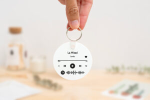 Llavero redondo personalizado con código Spotify, título de la canción y nombre del artista en un lado, y una imagen personalizada en el otro.