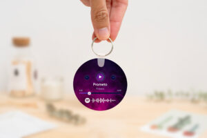 Llavero redondo personalizado con código Spotify, título de la canción y nombre del artista en un lado, y una imagen personalizada en el otro.