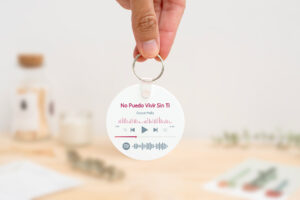 Llavero redondo personalizado con código Spotify, título de la canción y nombre del artista en un lado, y una imagen personalizada en el otro.