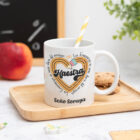 Taza personalizada con el texto ‘Maestra' y ‘La enseñanza es una obra del corazón', nombre de la profesora, curso y nombres de los niños en el reverso