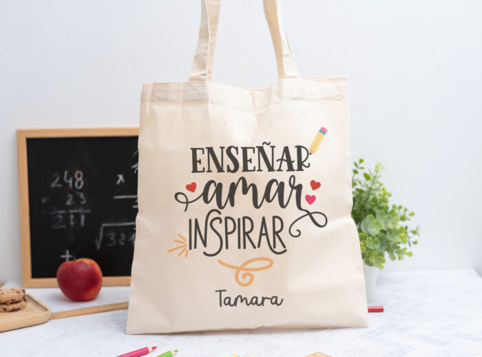 Tote bag personalizada con mensaje 'Enseñar, amar, inspirar', nombre de la profesora, curso y nombres de los niños en el reverso