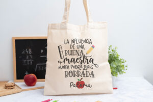 Tote bag personalizada con mensaje 'La influencia de una buena maestra nunca podrá ser borrada', nombre de la profesora, curso y nombres de los niños en el reverso
