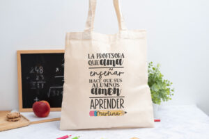 Tote bag personalizada con mensaje ‘La profesora que ama enseñar hace que sus alumnos amen aprender', nombre de la profesora, curso y nombres de los niños en el reverso